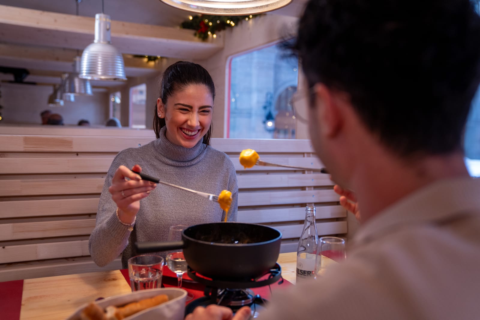 Gäste bei einem gemeinsamen Essen im Parsennbahn Fondue-Express