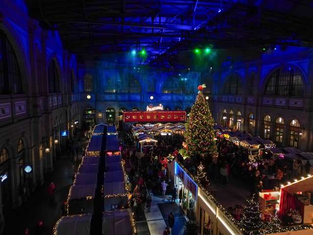Blick von oben über die Marktgassen zum Weihnachtsbaum, darüber die blau beleuchtete Hallendecke.