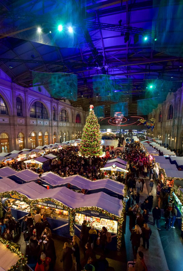 Die Bahnhofshalle mit Markthäusern und Weihnachtsbaum, Hochformat für Titelseiten und Social Media.