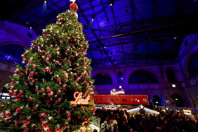 Der Lindt-Weihnachtsbaum, im Hintergrund der rote Wagen des Parsennbahn Fondue-Express.