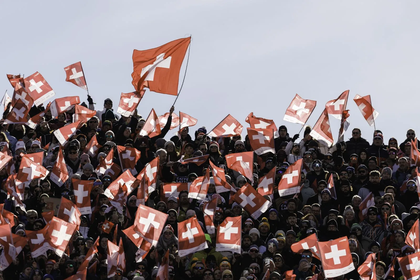 Fans schwenken Schweizer Fahnen im Zielraum einer Weltcup-Abfahrt in Crans-Montana
